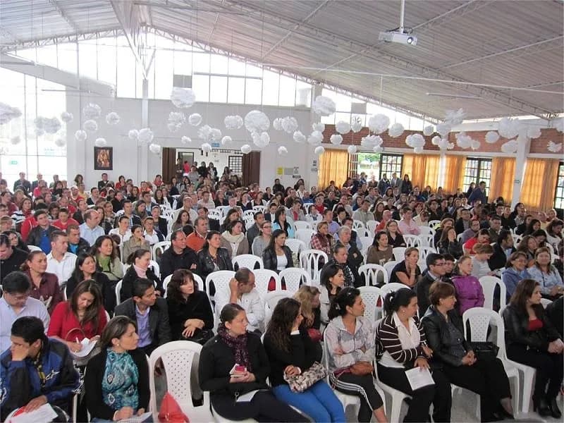 Salón decorado y completamente lleno de padres de familia en una conferencia