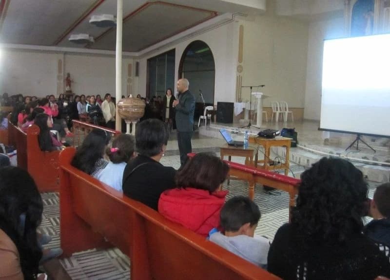 Asistentes atentos durante una charla en un recinto de techo abovedado