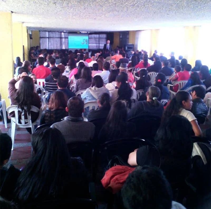 Vista desde atrás de un auditorio lleno durante una conferencia