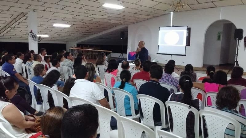Público siguiendo la proyección durante una conferencia