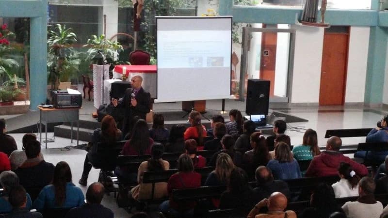 Conferencia en curso con la presentación proyectada en pantalla