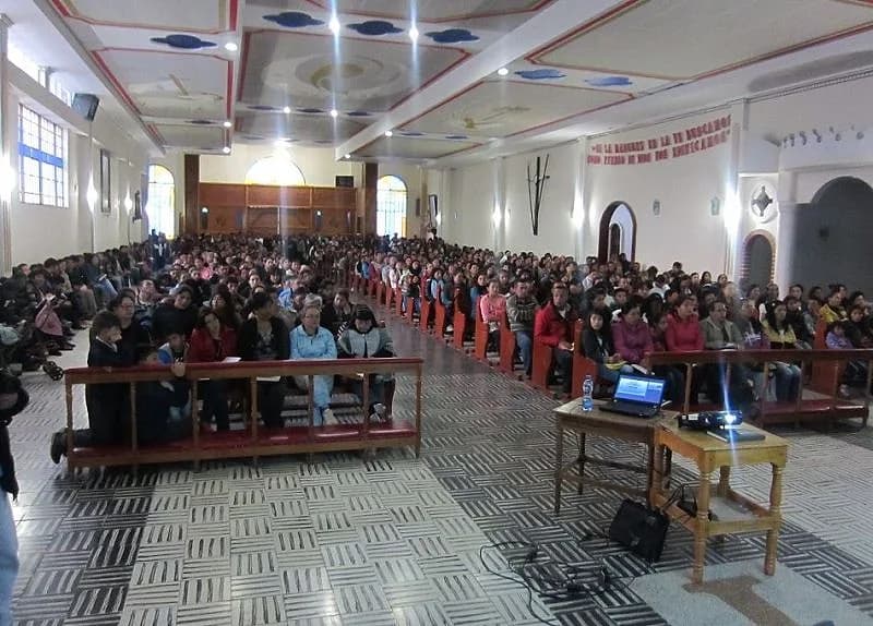 Recinto lleno de asistentes en bancas durante una conferencia de prevención