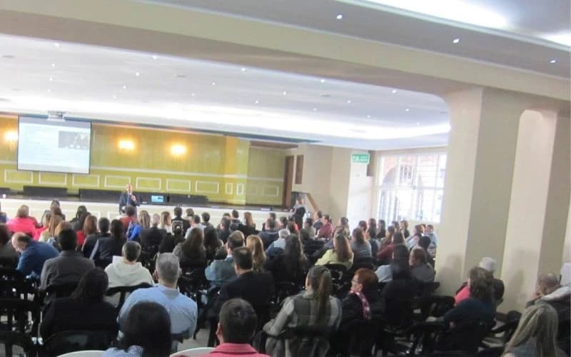 Salón amplio con el público ocupando todas las sillas durante una conferencia
